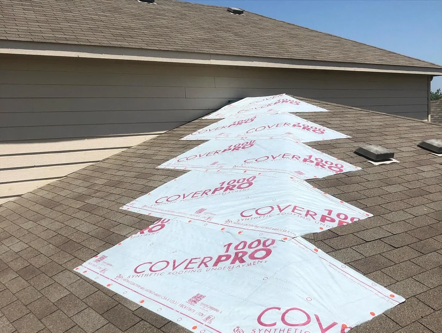 Asphalt shingle roof installation with synthetic underlayment and charcoal gray composition shingles