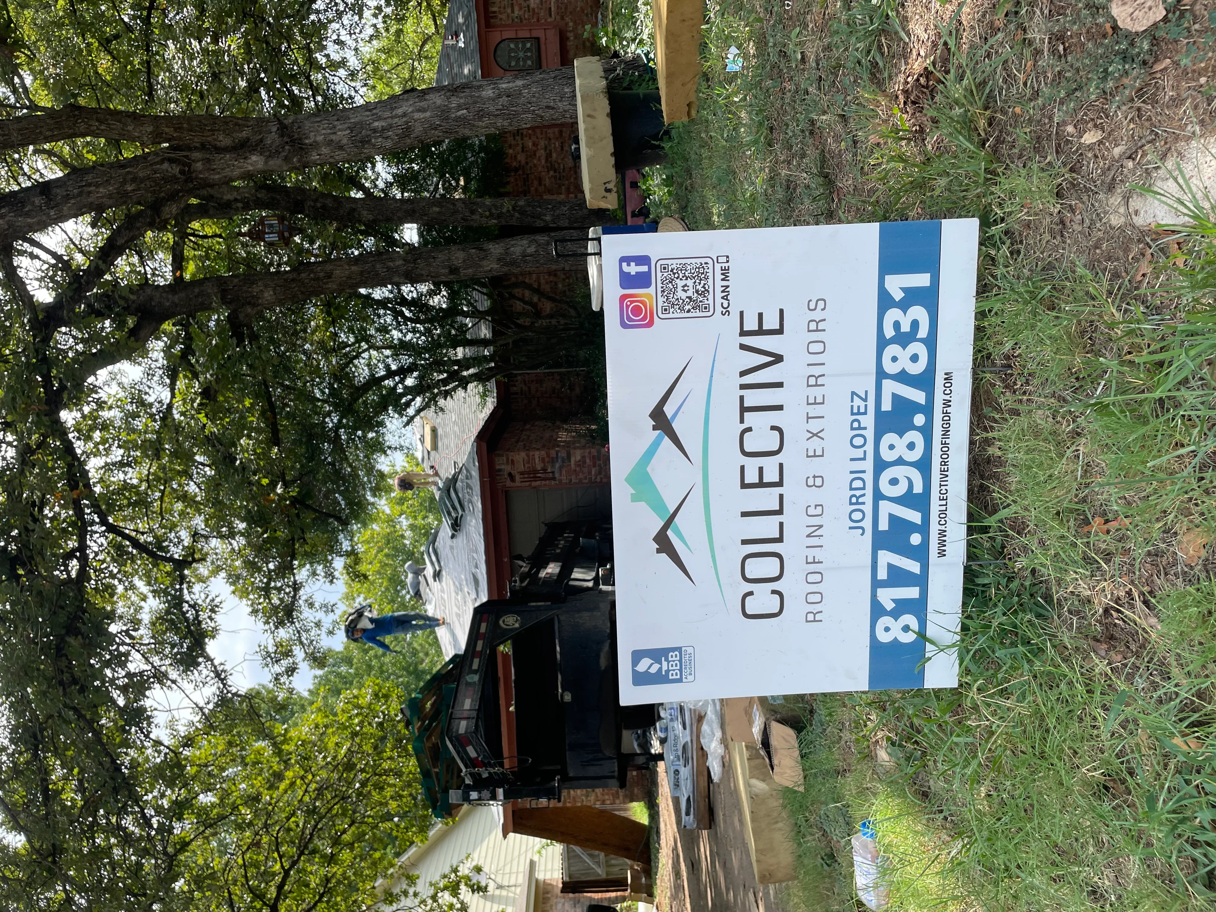 Roofing contractor yard sign with company logo and contact information installed at job site
