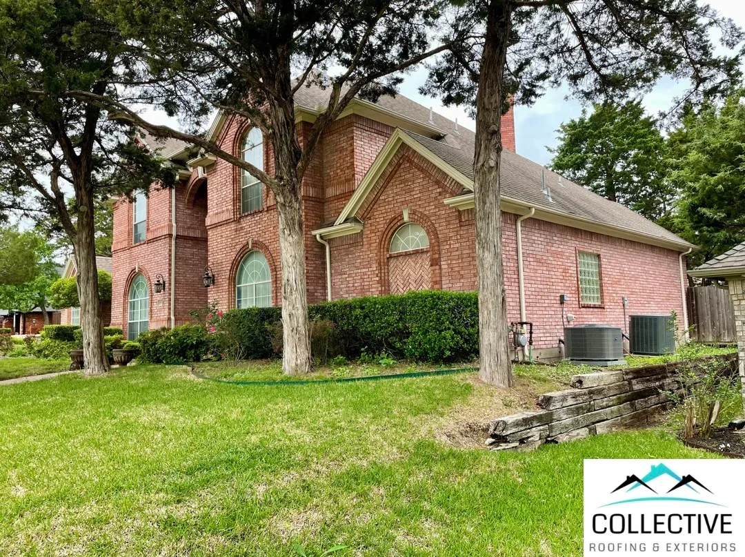 Two-story brick home with new architectural shingle roof, gutters, and restored exterior trim