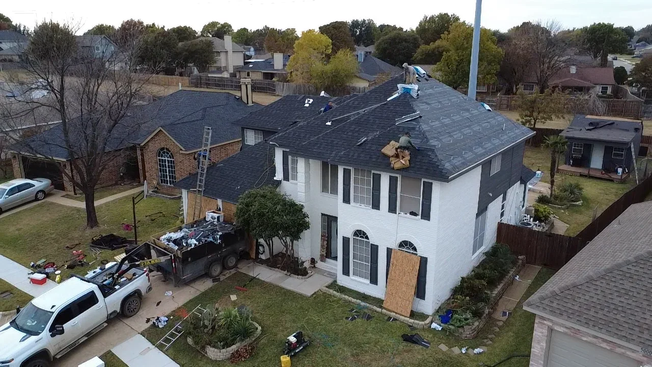 Two-story home with new charcoal gray architectural shingle roof installation in progress