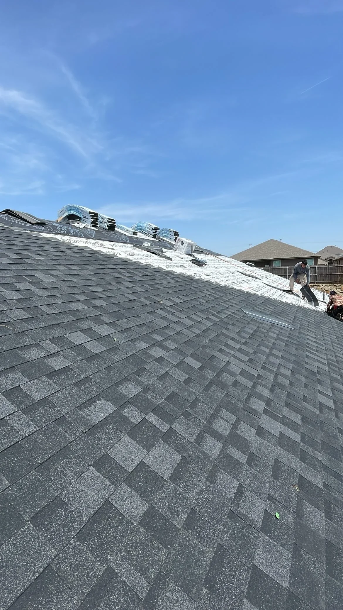 Charcoal gray architectural shingles with skylight installations and proper flashing on steep-pitch residential roof