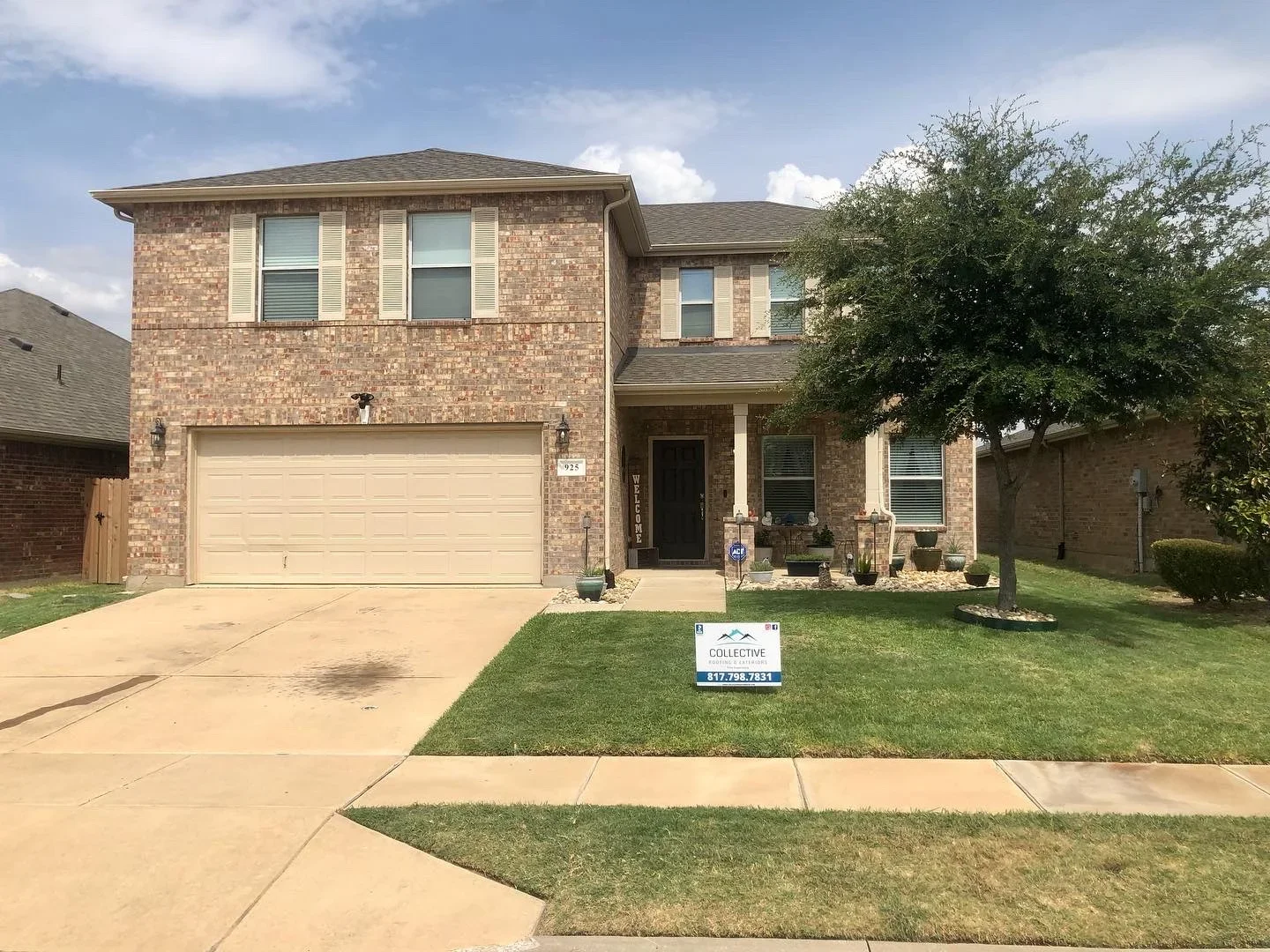 Two-story brick home with new asphalt shingle roof installation, multiple roof planes and hip design