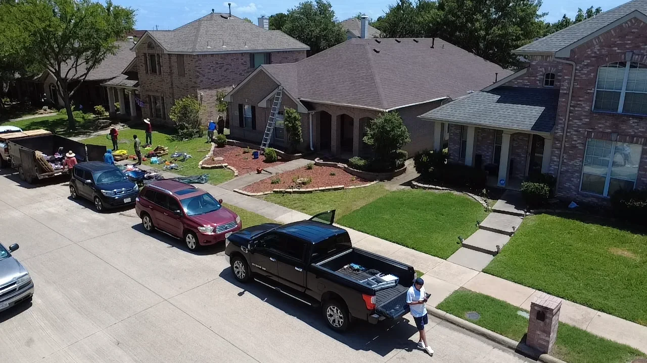 New asphalt shingle roofs installed on multiple brick residential homes with gray shingles