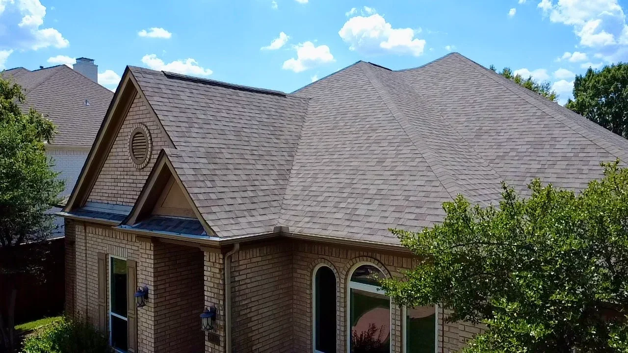 Charcoal gray architectural shingles on multi-pitched residential roof with complex geometry