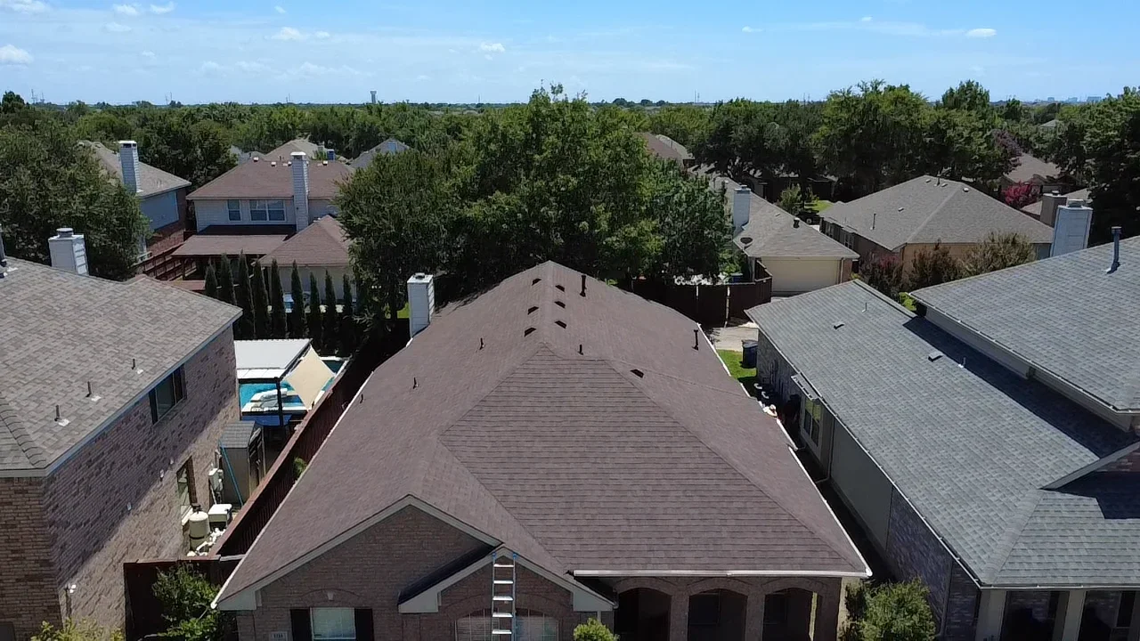 Dark brown asphalt shingle roof with multiple gables on brick residential home