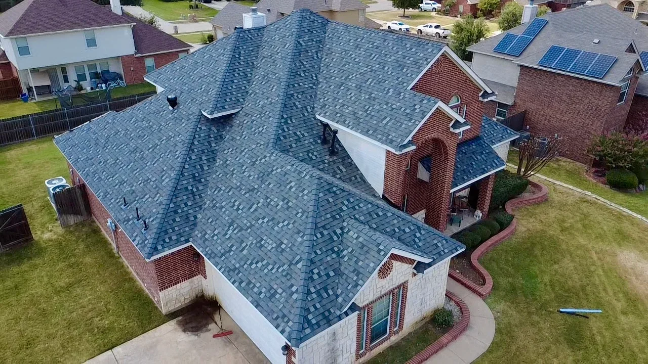 Slate blue architectural shingle roof with hip and valley design on brick home with dormers