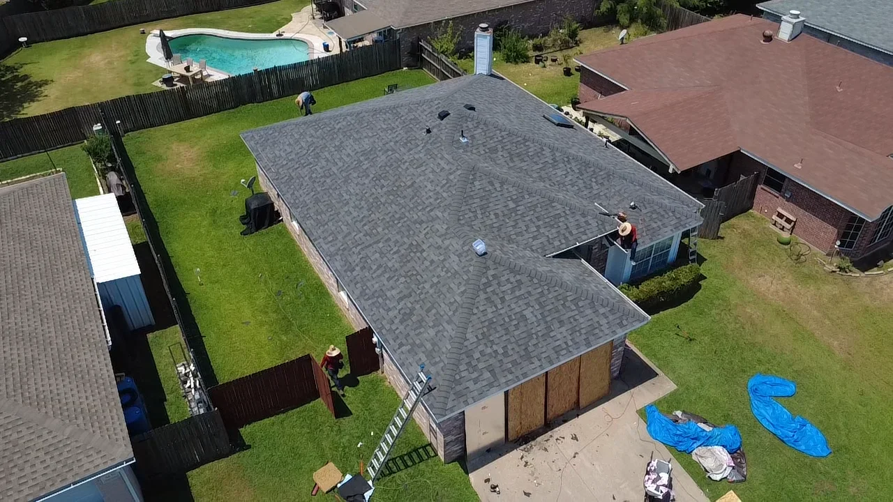 Gray architectural asphalt shingle roof installation on residential home with proper flashing and ventilation