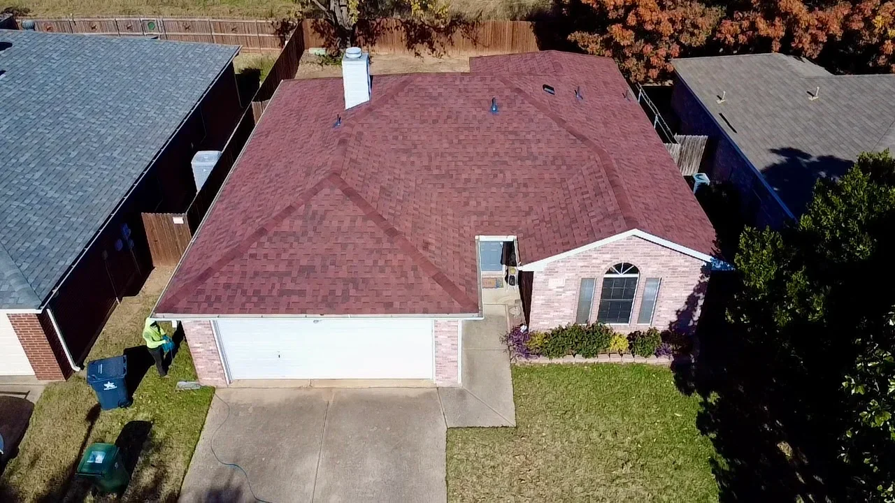 Burgundy asphalt shingle roof with dormers and chimney flashing on residential home