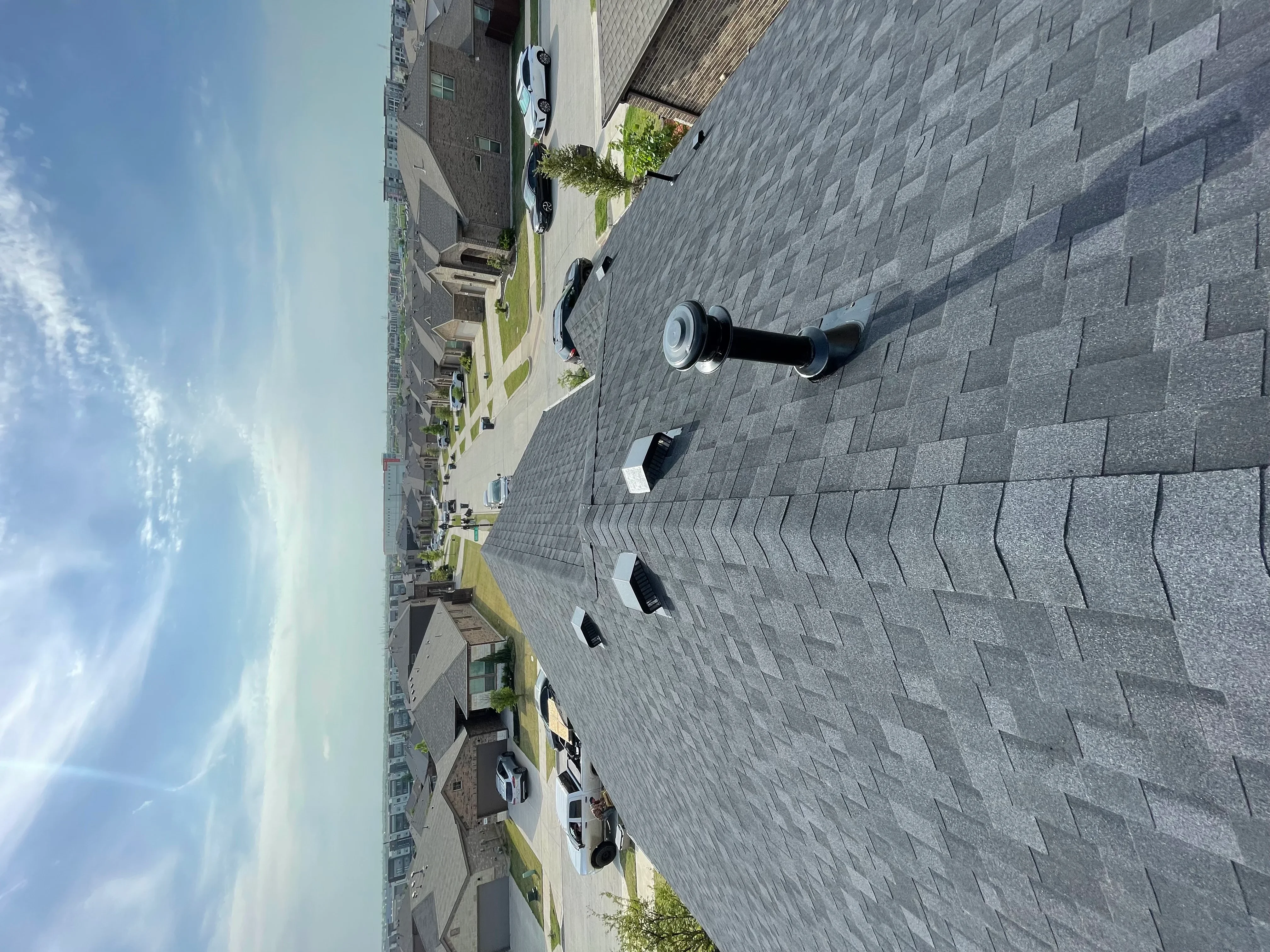 Gray architectural shingles with roof vents and flashing on residential home