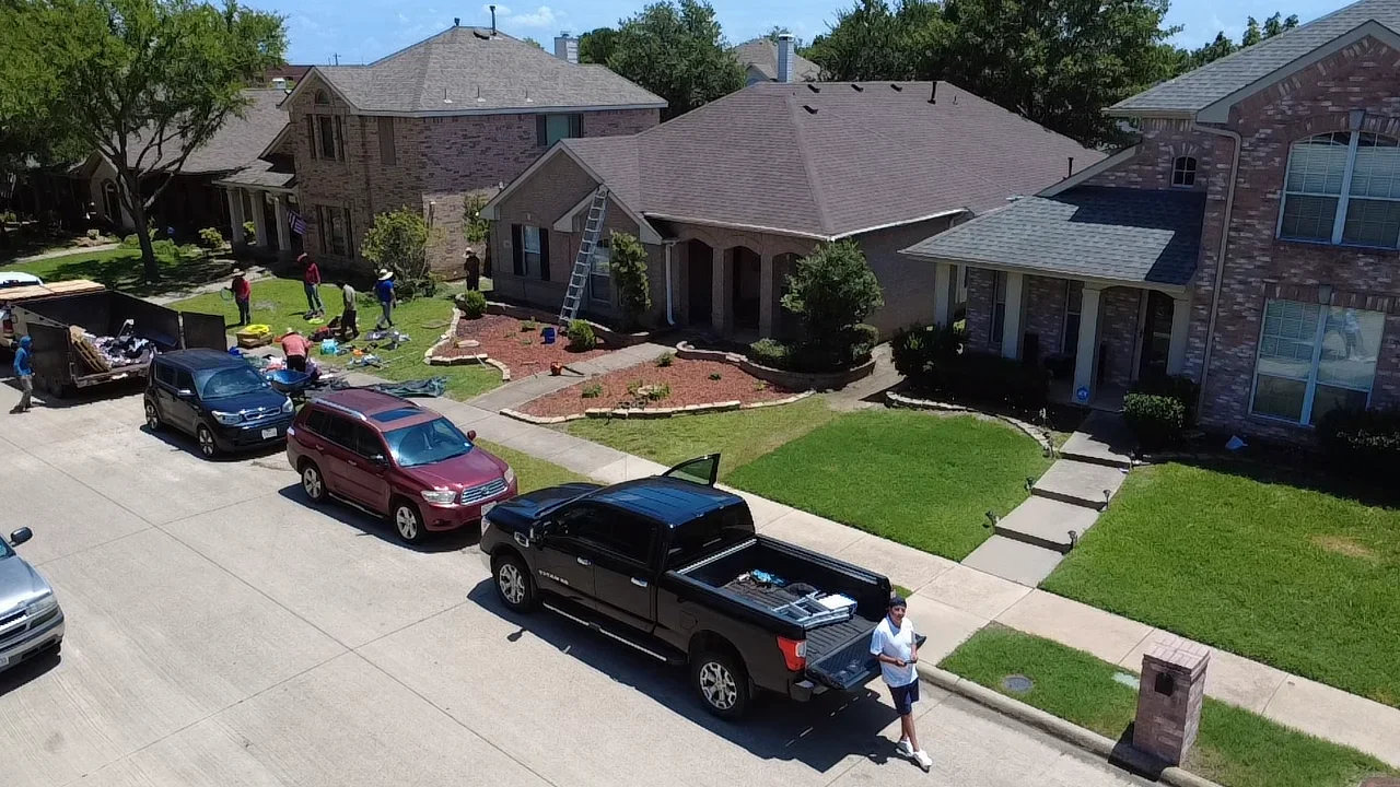 New gray asphalt shingle roof installation on two-story brick home with multiple roof planes