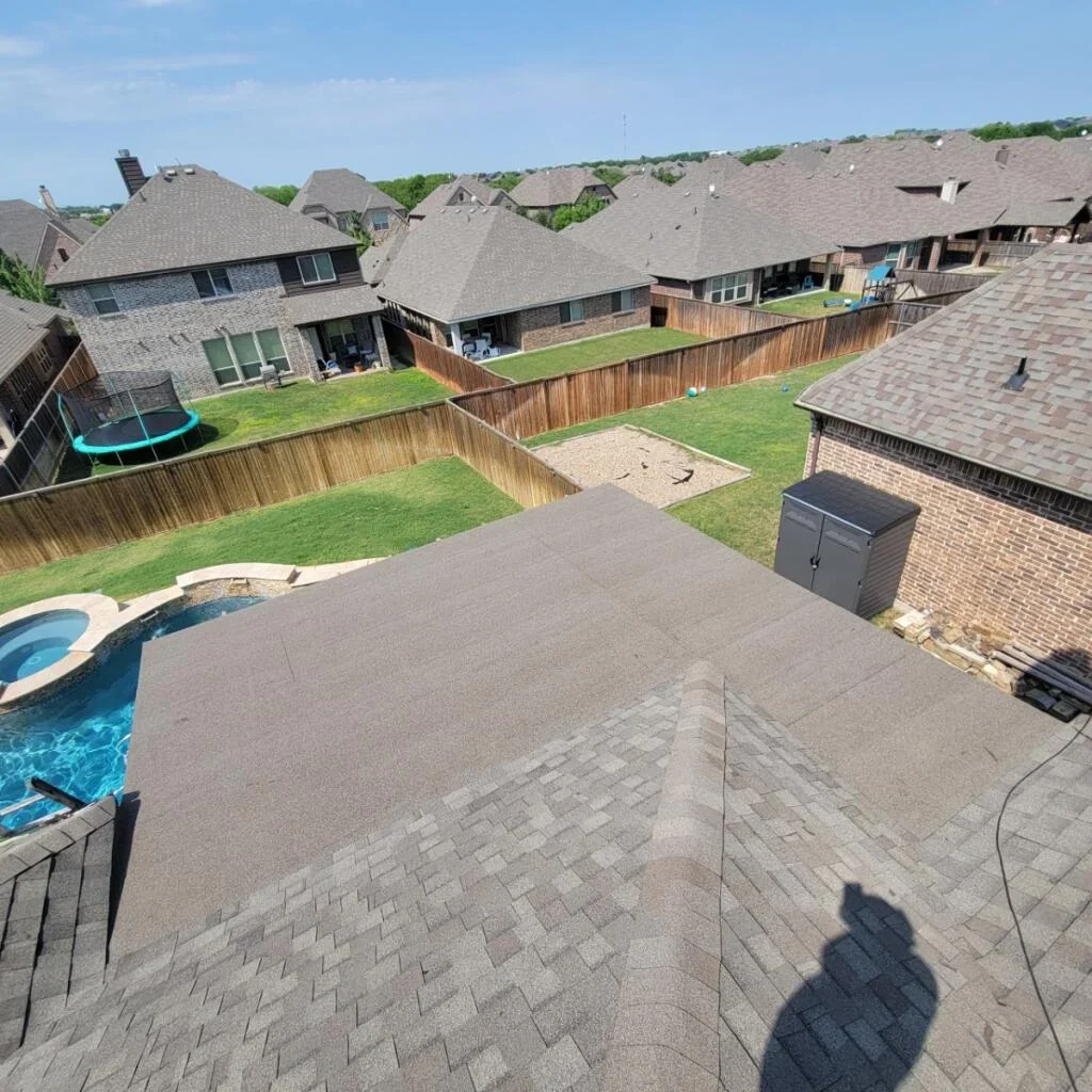 Asphalt shingle roof installation on multi-plane residential home with brick exterior