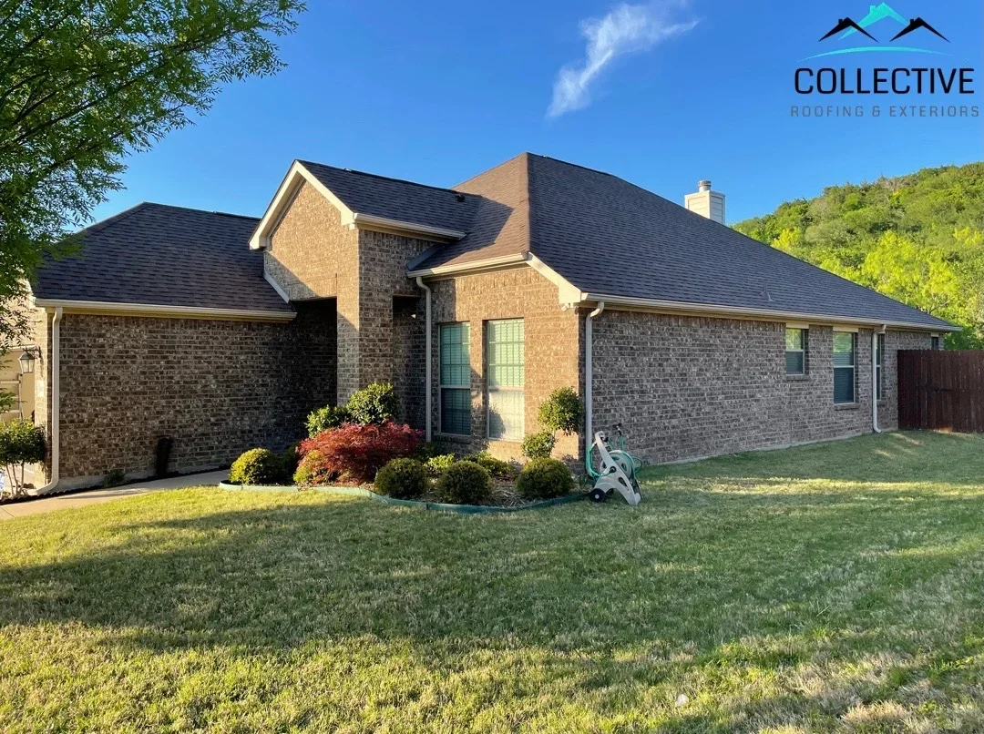 Dark architectural shingles on brick home with multiple roof planes and chimney flashing