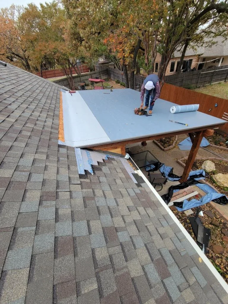 Blue waterproof membrane flat roof installation with white trim and wooden support structure