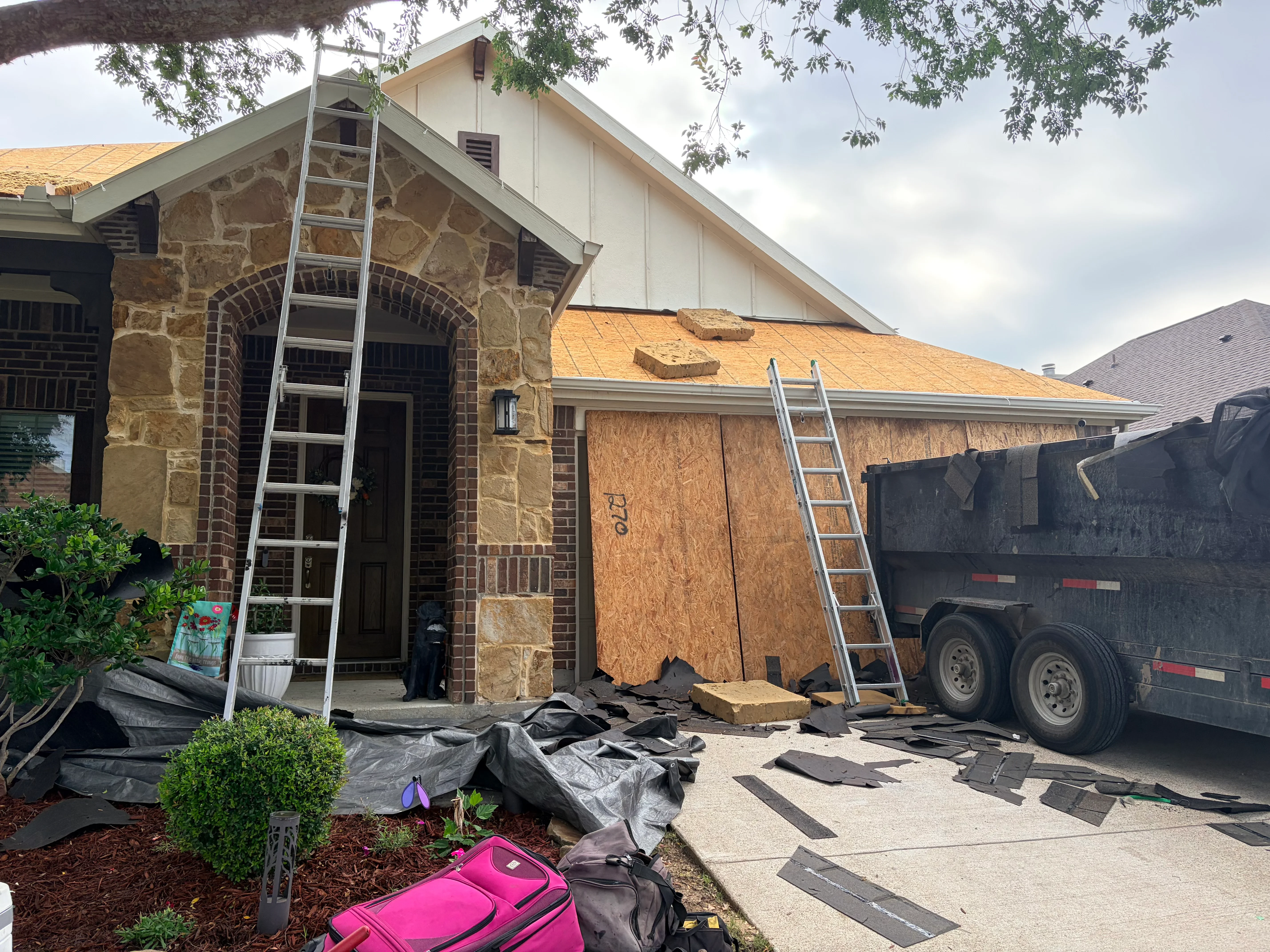 Residential roof replacement with new asphalt shingles, exposed sheathing, and removal debris